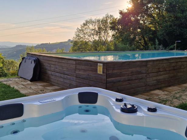 Piscina e vasca idromassaggio in giardino con vista panoramica.