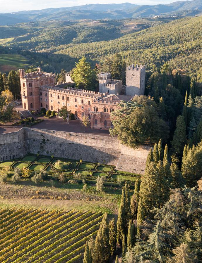 Château historique entouré de collines et de vignobles.