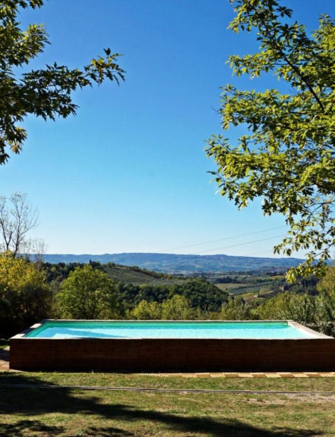 Pool with panoramic view of green hills.